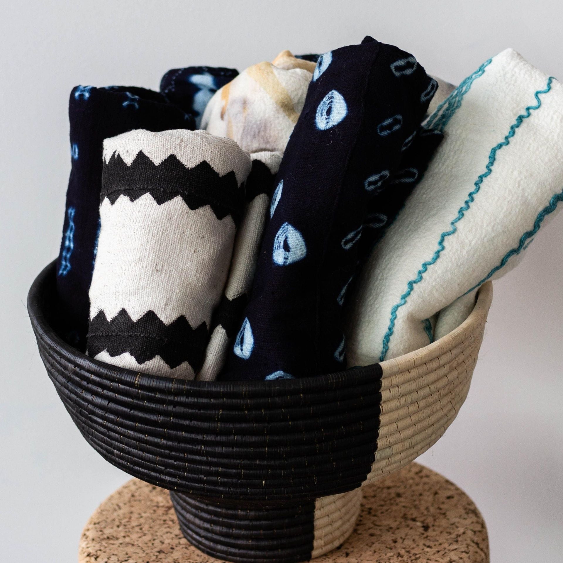 Bowl filled with patterned black and white fabrics on a light background
