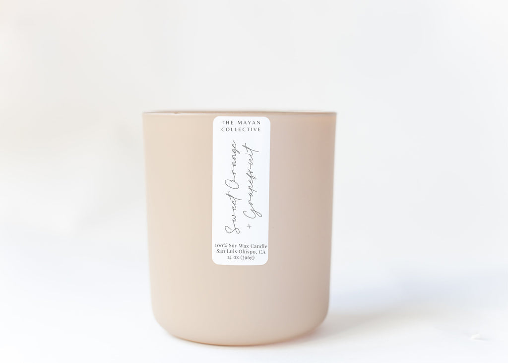Beige candle with a white label on a light beige background